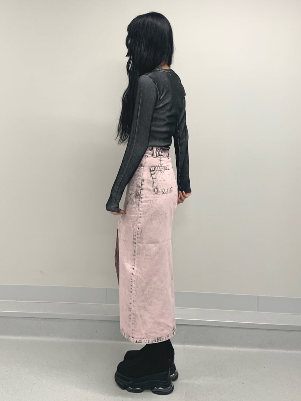 ブラック系のブーツ、ブラック系のニット/セーター、ピンク系のデニムスカートを着用したレディースの春コーディネートの3枚目の写真