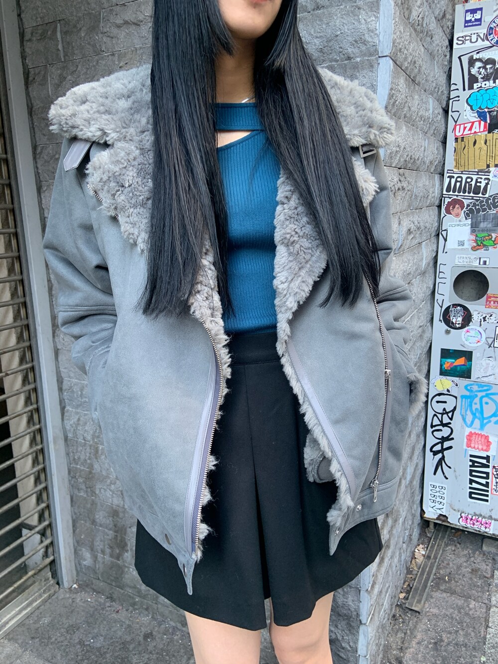 グレー系のムートンコート、ブルー系のニット/セーター、ブラック系のその他パンツを着用したレディースの冬コーディネートの5枚目の写真
