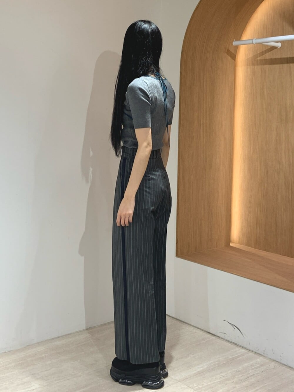 ブラック系のブーツ、グレー系のニット/セーター、グレー系のスラックスを着用したレディースの春コーディネートの3枚目の写真