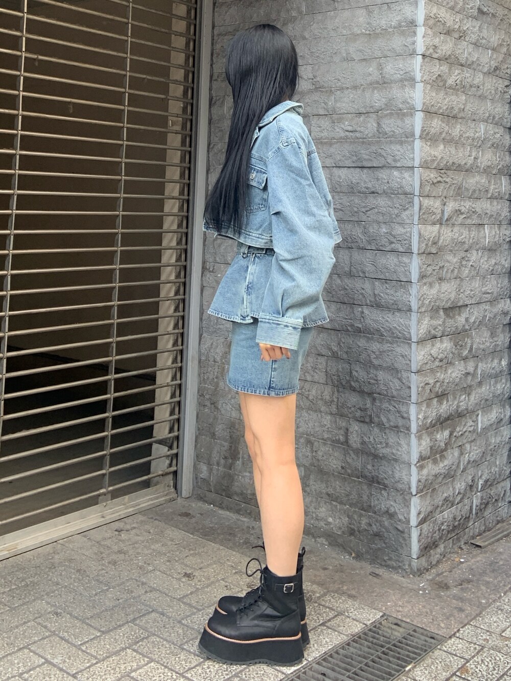 ブラック系のブーツ、ブルー系のデニムジャケット、ブルー系のその他トップスを着用したレディースの冬コーディネートの3枚目の写真