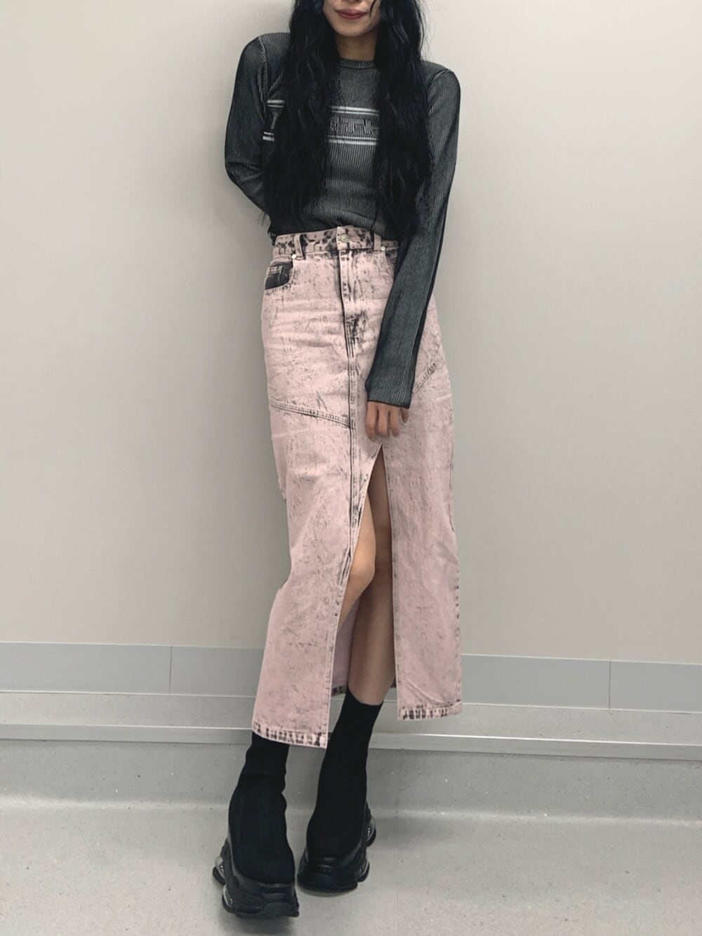 ブラック系のブーツ、ブラック系のニット/セーター、ピンク系のデニムスカートを着用したレディースの春コーディネートの2枚目の写真