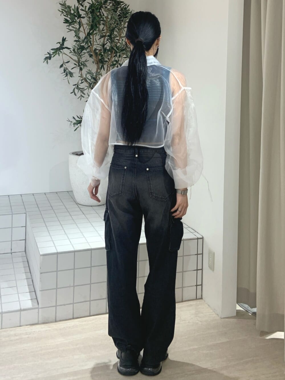 ブラック系のデニムパンツ、ブラック系のスニーカー、ホワイト系のシャツ/ブラウスを着用したレディースの春コーディネートの4枚目の写真