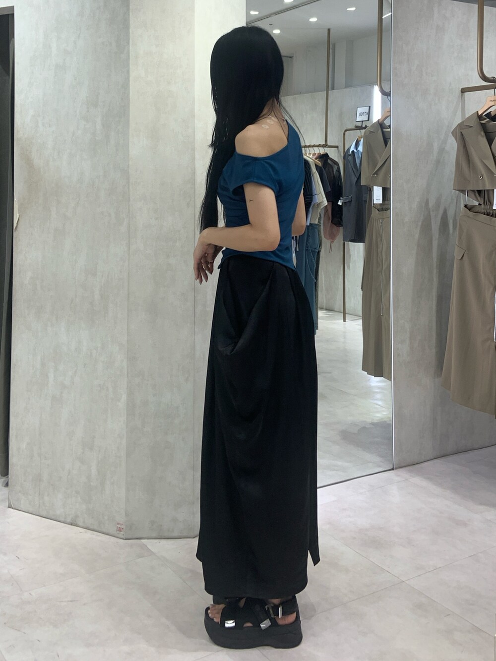 ブルー系のTシャツ/カットソー、ブラック系のスカートを着用したレディースの夏コーディネートの3枚目の写真