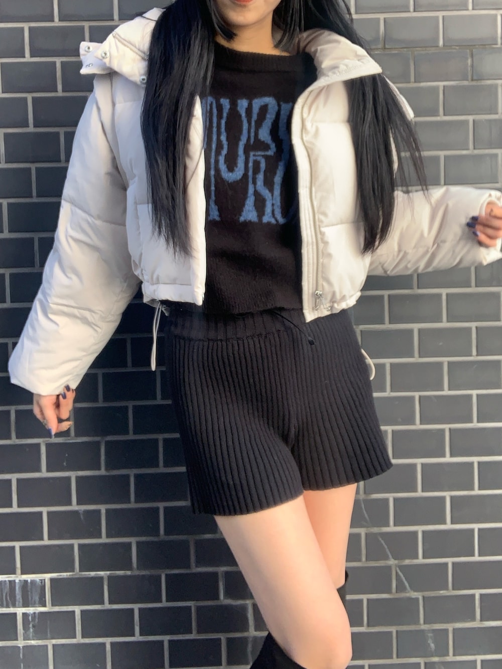 ホワイト系のブルゾン、ブラック系のニット/セーター、ブラック系のその他パンツを着用したレディースの冬コーディネートの4枚目の写真