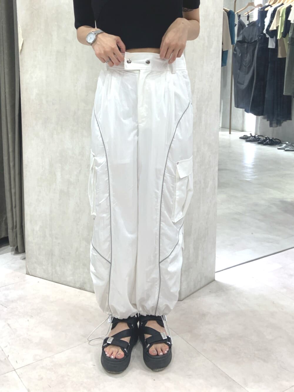 ブラック系のサンダル、ブラック系のニット/セーター、ホワイト系のカーゴパンツを着用したレディースの春コーディネートの6枚目の写真