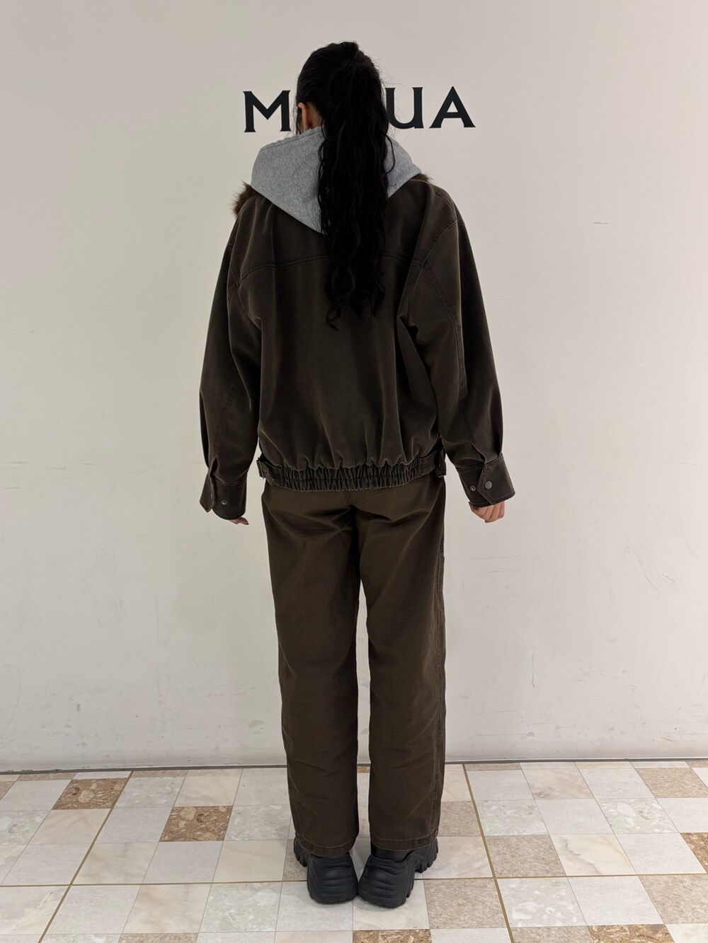 ブラウン系のブルゾン、グレー系のパーカー、ブラウン系のその他パンツを着用したレディースの冬コーディネートの3枚目の写真