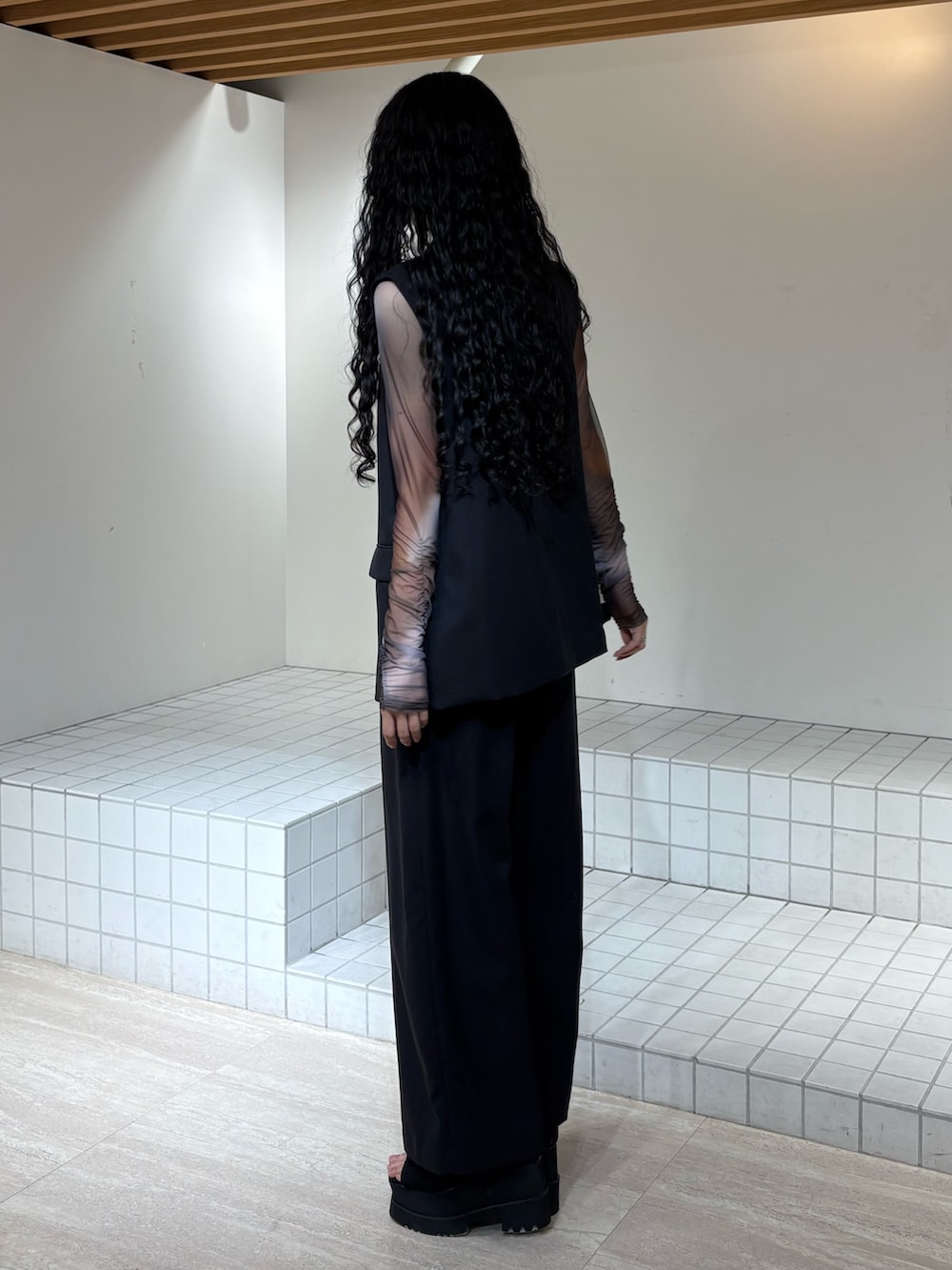 ブラック系のベスト、ブラック系のスラックス、ブラウン系のTシャツ/カットソーを着用したレディースの春コーディネートの2枚目の写真