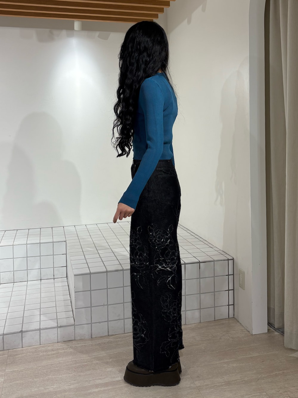 ブルー系のニット/セーター、ブラック系のデニムパンツを着用したレディースの冬コーディネートの2枚目の写真