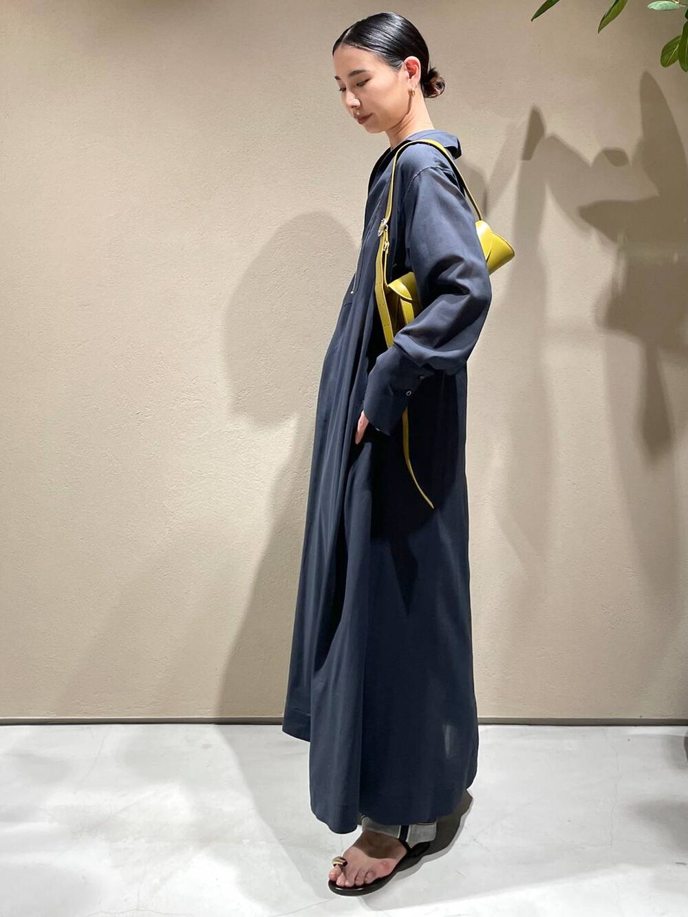 ブルー系のデニムパンツ、ホワイト系のチューブトップ、グレー系のワンピースを着用したレディースの春コーディネートの3枚目の写真