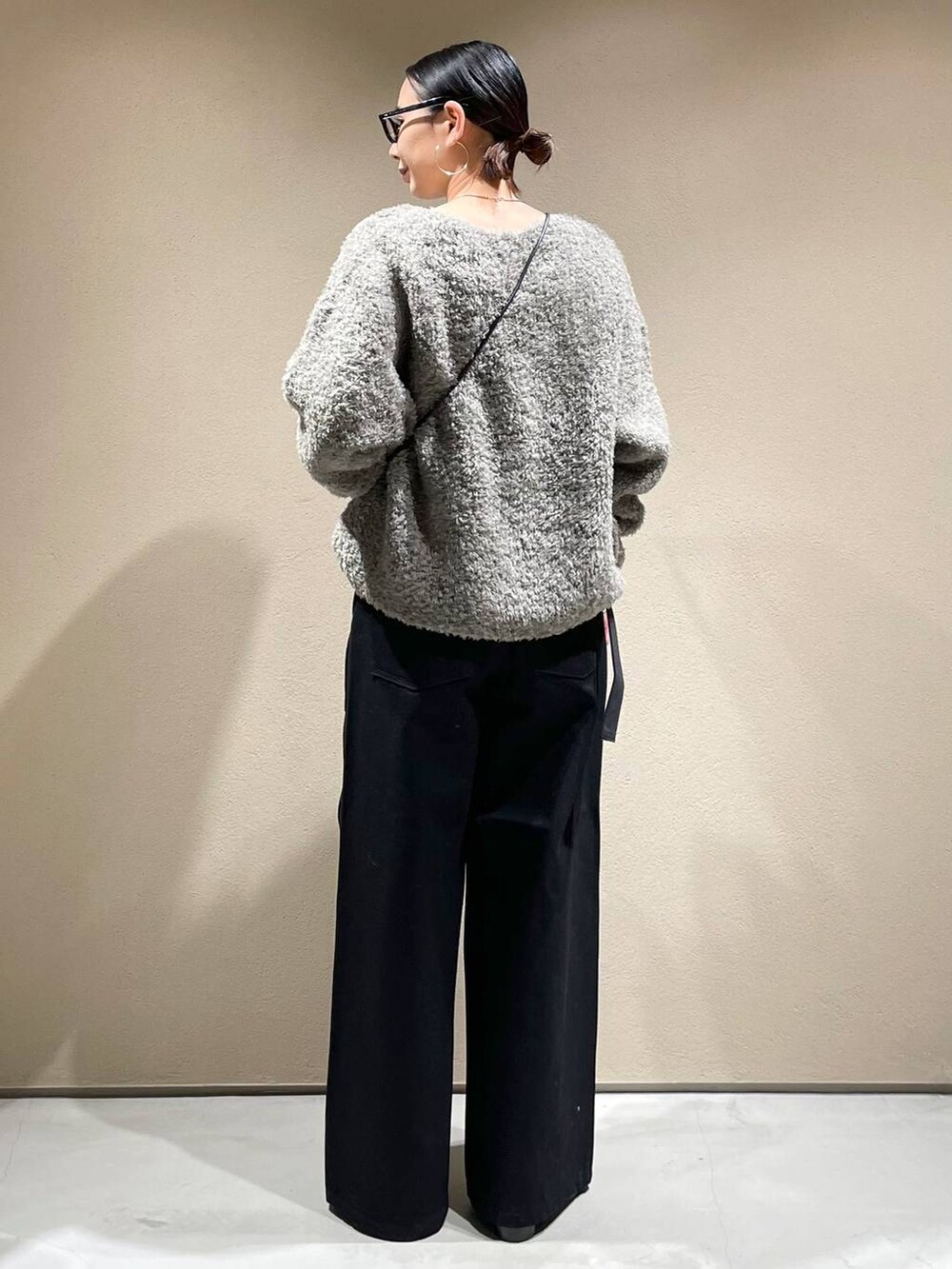 ホワイト系のTシャツ/カットソー、グレー系のニット/セーター、ブラック系のデニムパンツを着用したレディースの冬コーディネートの3枚目の写真