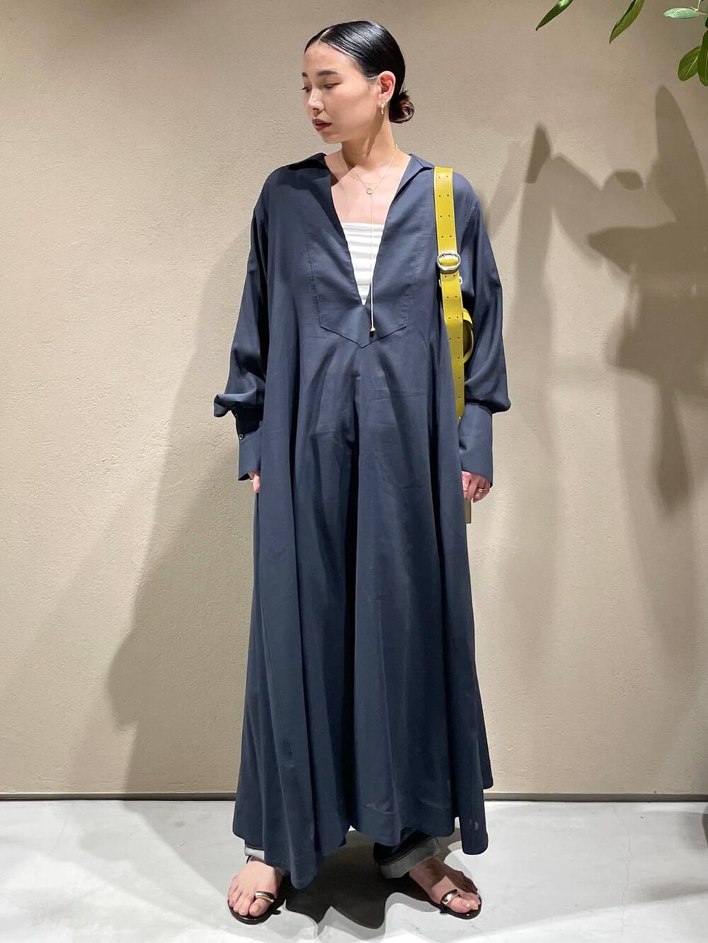 ブルー系のデニムパンツ、ホワイト系のチューブトップ、グレー系のワンピースを着用したレディースの春コーディネートの2枚目の写真