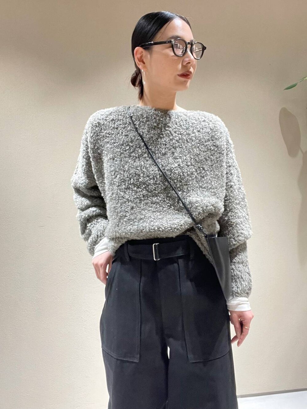 ホワイト系のTシャツ/カットソー、グレー系のニット/セーター、ブラック系のデニムパンツを着用したレディースの冬コーディネートの4枚目の写真