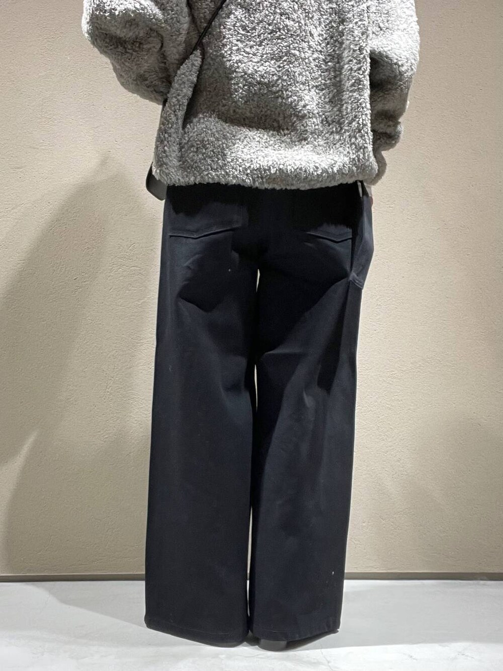 ホワイト系のTシャツ/カットソー、グレー系のニット/セーター、ブラック系のデニムパンツを着用したレディースの冬コーディネートの6枚目の写真