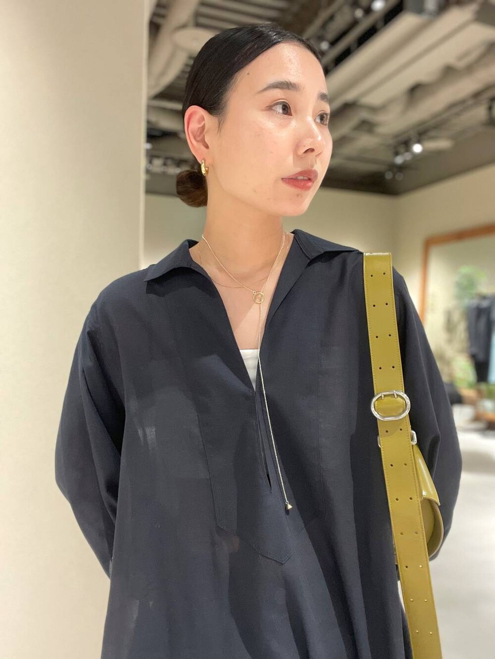 ブルー系のデニムパンツ、ホワイト系のチューブトップ、グレー系のワンピースを着用したレディースの春コーディネートの7枚目の写真