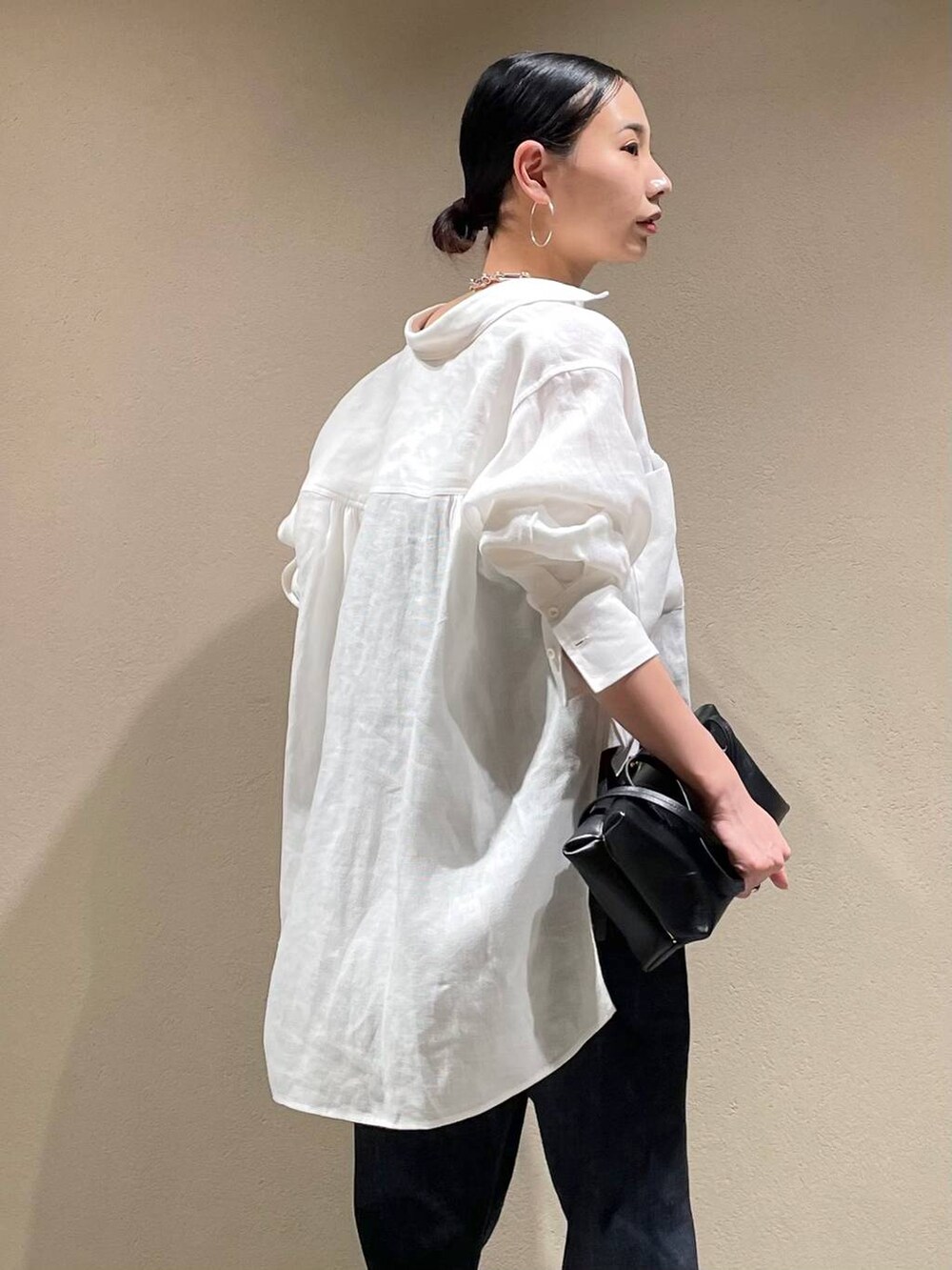 ブルー系のデニムパンツ、ホワイト系のシャツ/ブラウス、ブラック系のベストを着用したレディースの春コーディネートの7枚目の写真
