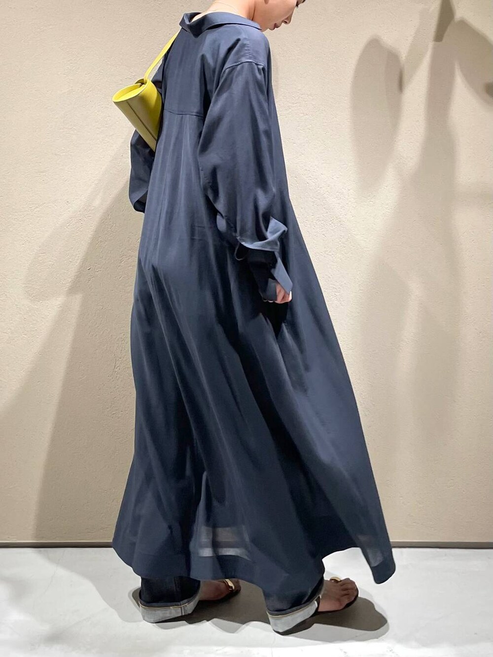 ブルー系のデニムパンツ、ホワイト系のチューブトップ、グレー系のワンピースを着用したレディースの春コーディネートの6枚目の写真
