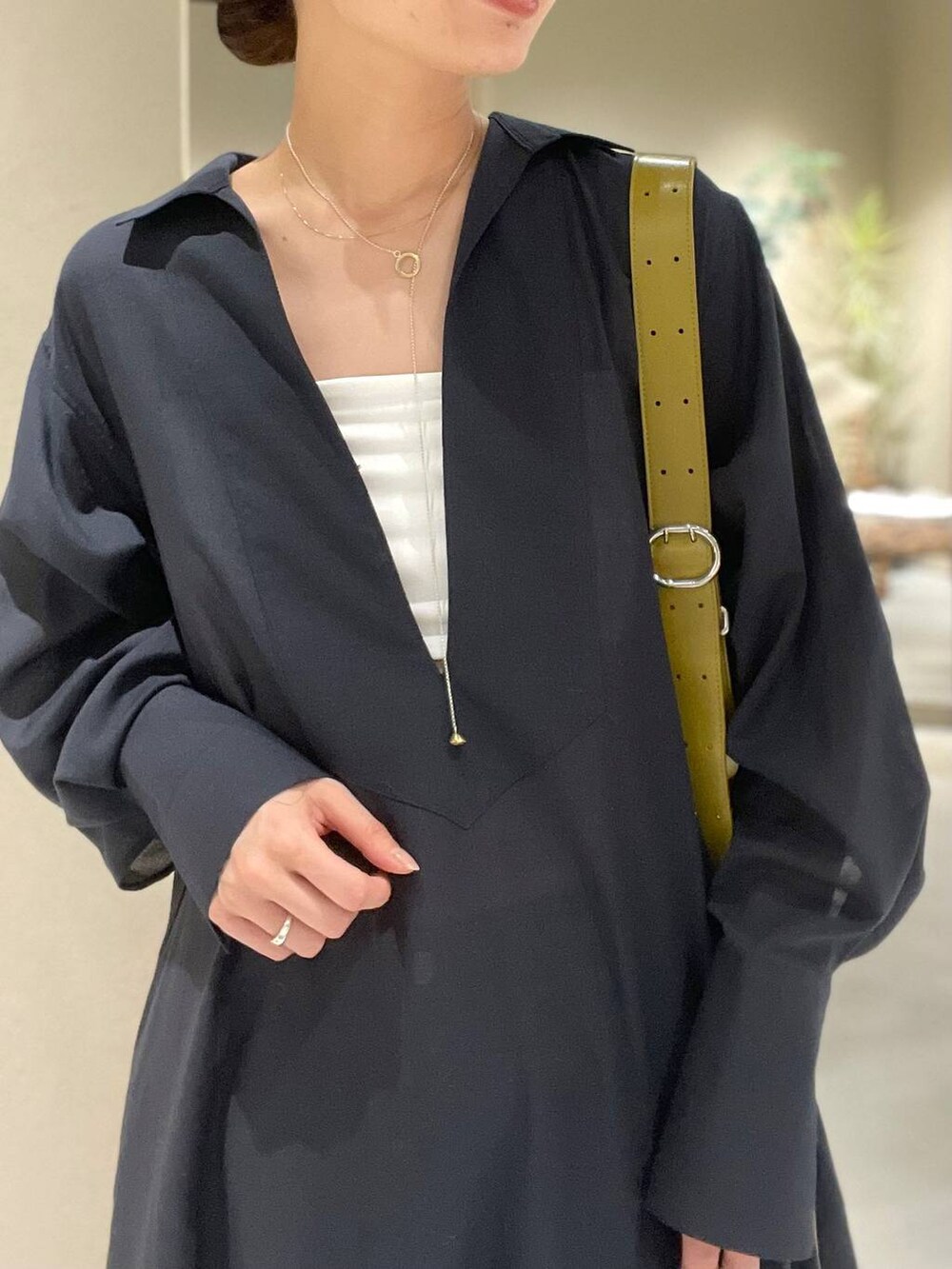 ブルー系のデニムパンツ、ホワイト系のチューブトップ、グレー系のワンピースを着用したレディースの春コーディネートの8枚目の写真