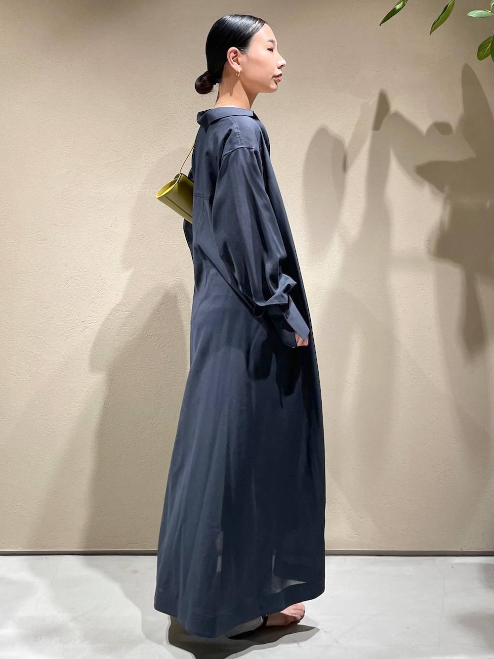 ブルー系のデニムパンツ、ホワイト系のチューブトップ、グレー系のワンピースを着用したレディースの春コーディネートの5枚目の写真