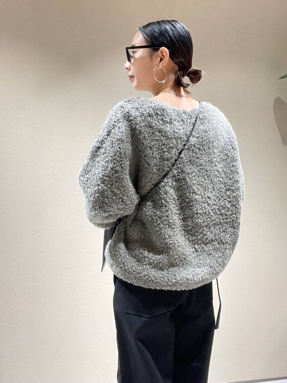 ホワイト系のTシャツ/カットソー、グレー系のニット/セーター、ブラック系のデニムパンツを着用したレディースの冬コーディネートの5枚目の写真