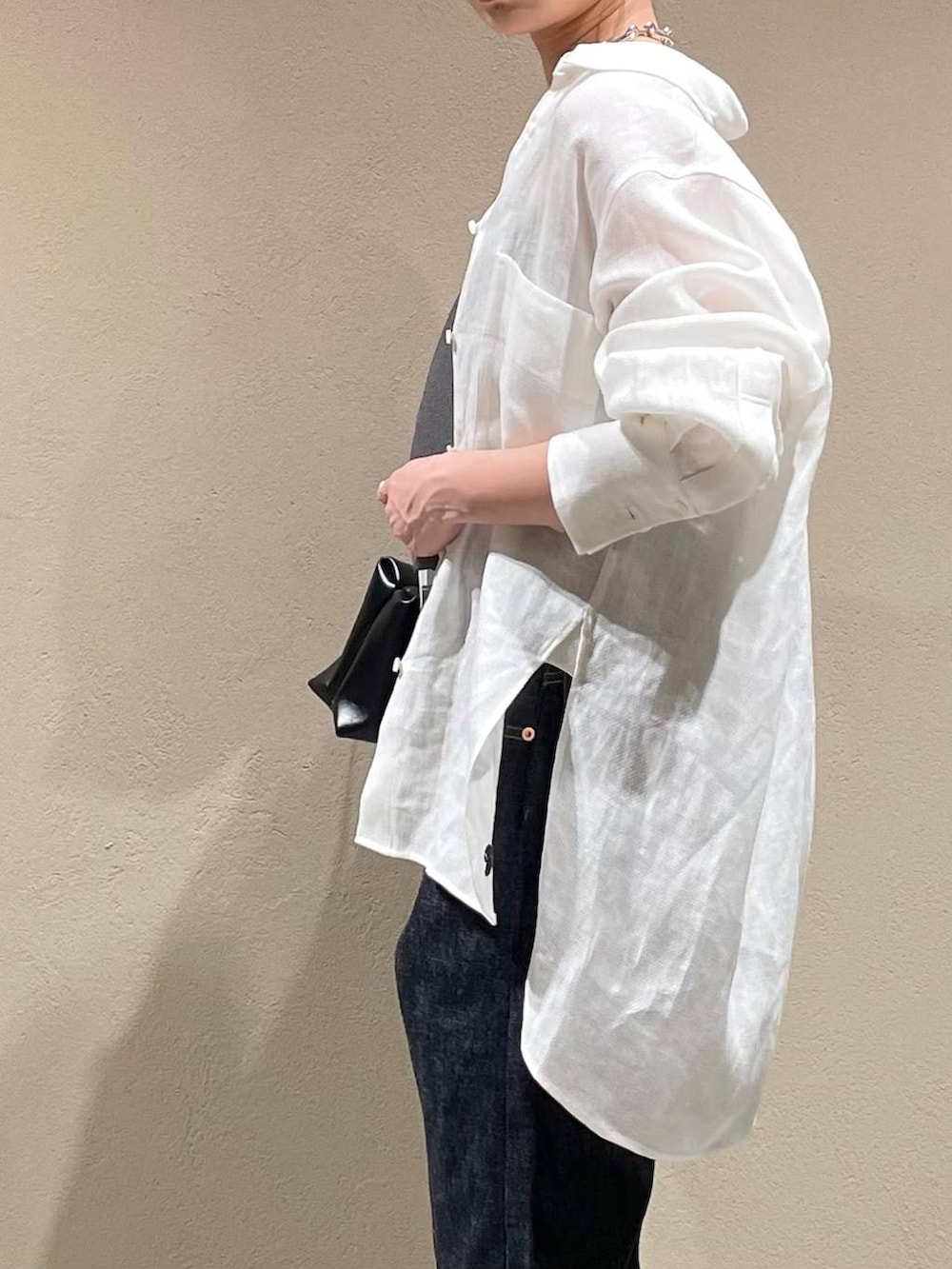 ブルー系のデニムパンツ、ホワイト系のシャツ/ブラウス、ブラック系のベストを着用したレディースの春コーディネートの6枚目の写真