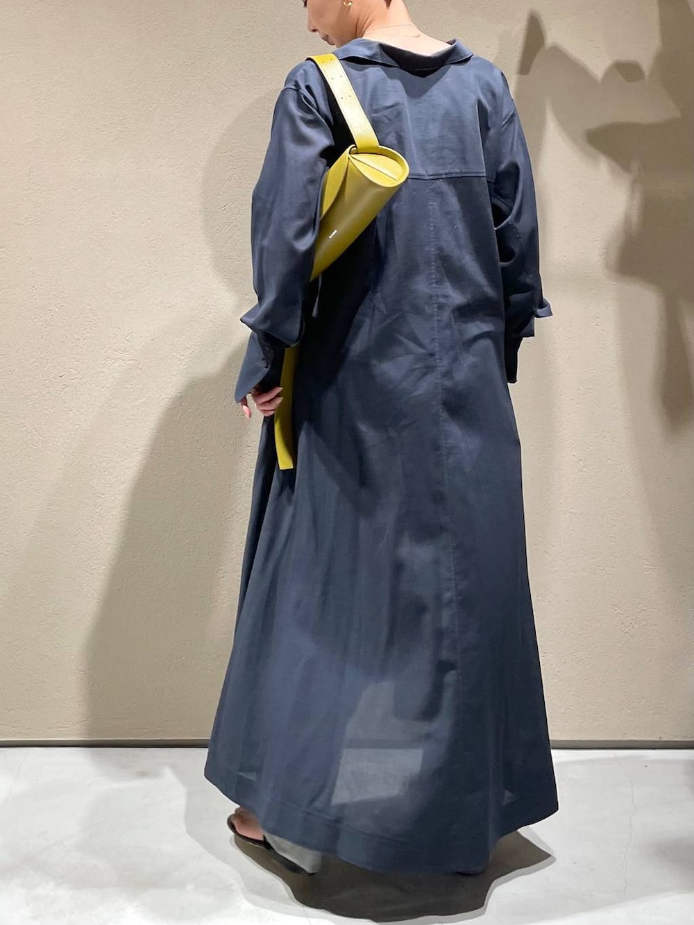 ブルー系のデニムパンツ、ホワイト系のチューブトップ、グレー系のワンピースを着用したレディースの春コーディネートの4枚目の写真