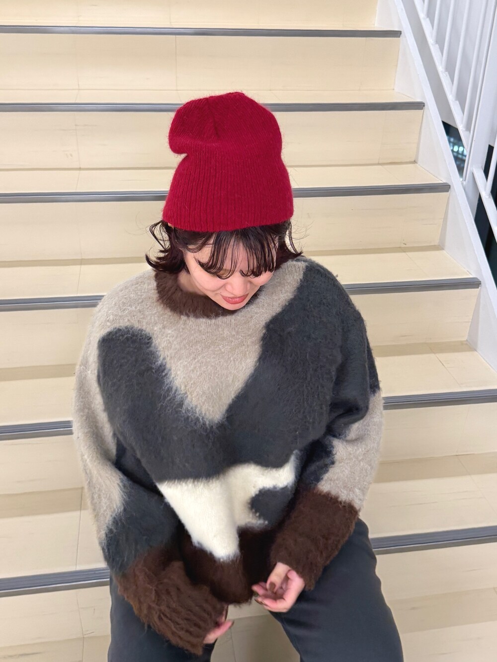 グレー系のニット/セーター、ブルー系のデニムジャケット、グレー系のスウェットパンツを着用したレディースの秋コーディネートの6枚目の写真