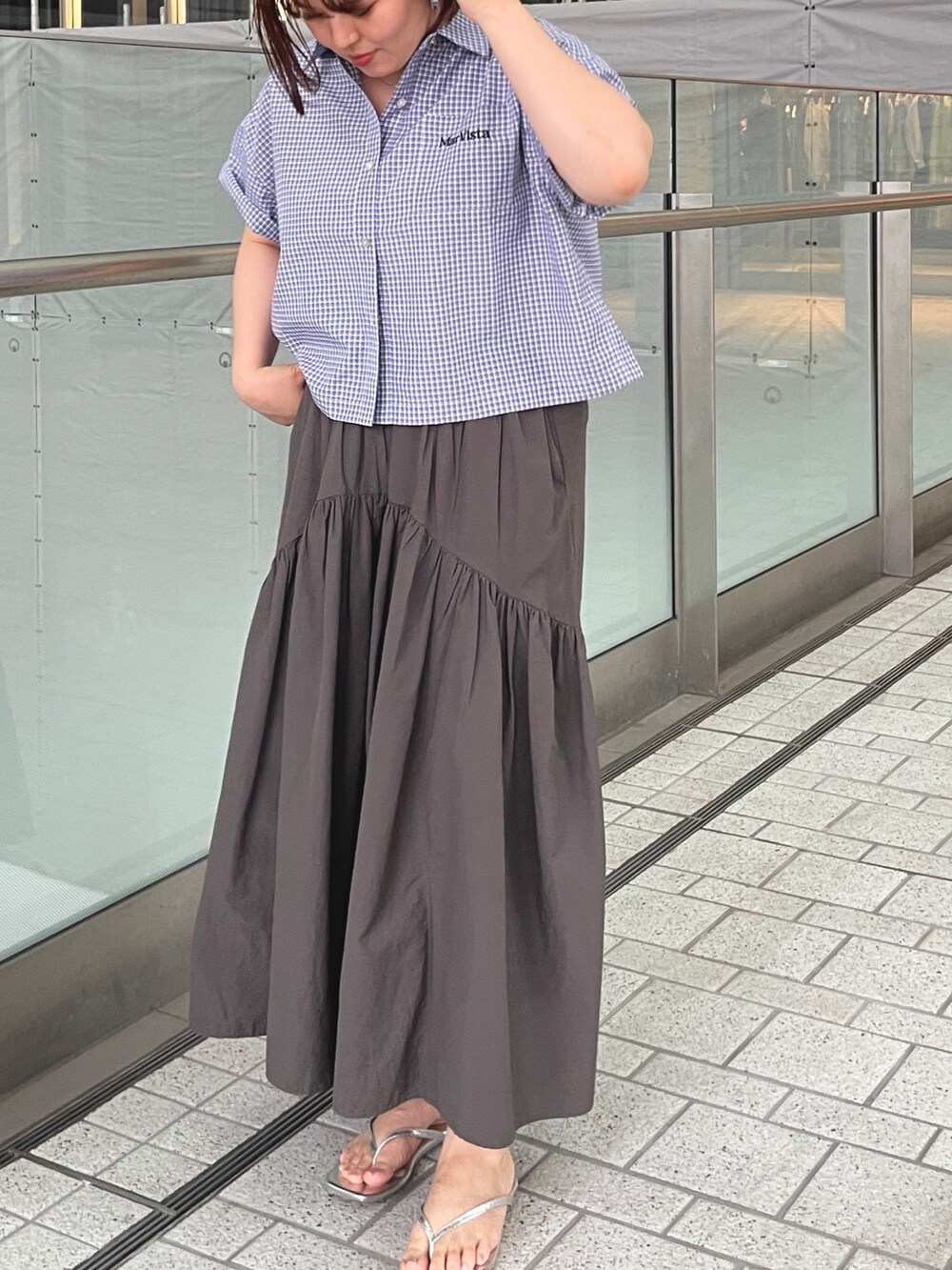 ブラック系のシャツ/ブラウス、グレー系のスカート、シルバー系のサンダルを着用したレディースの夏コーディネートの3枚目の写真