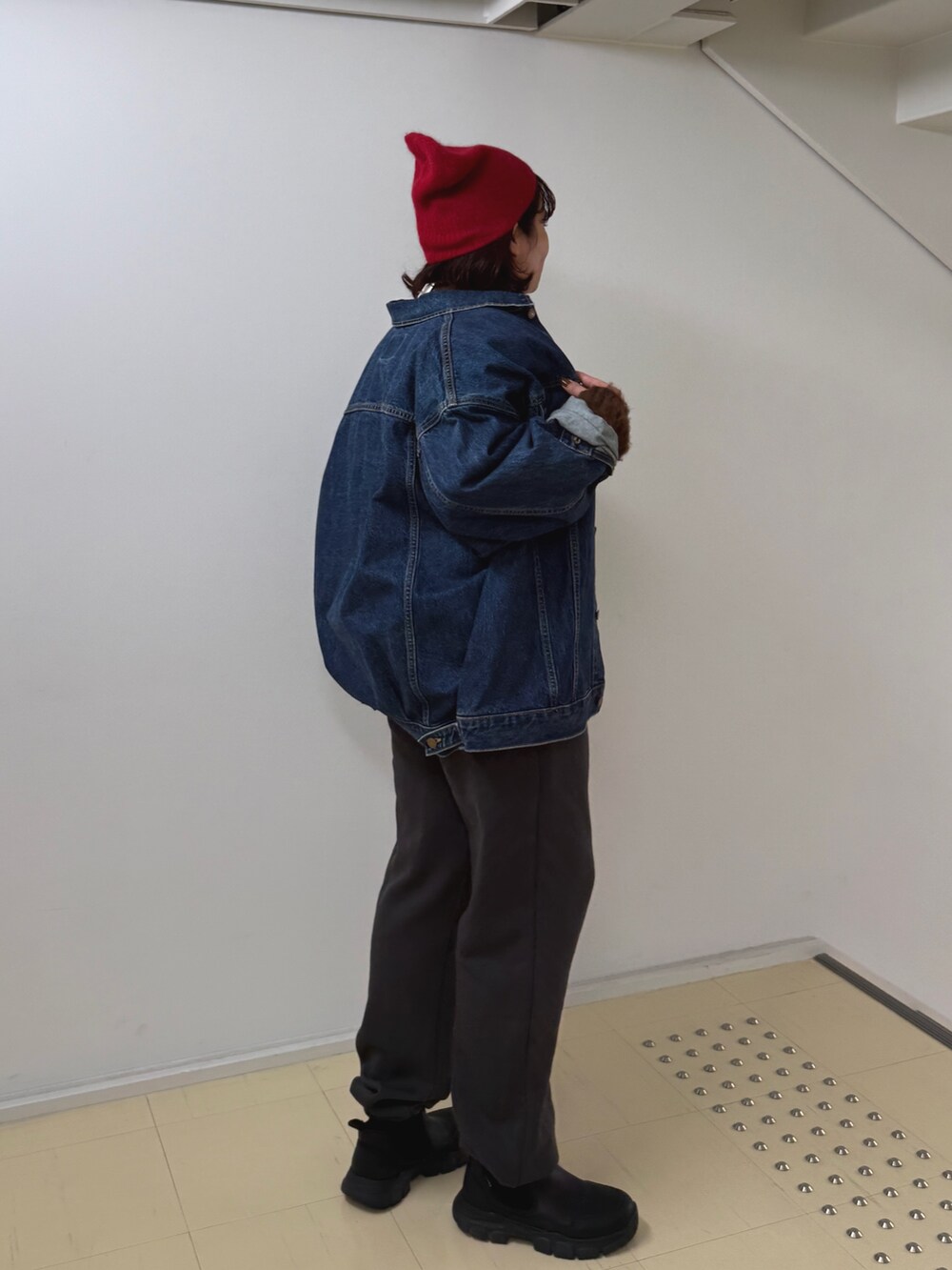 グレー系のニット/セーター、ブルー系のデニムジャケット、グレー系のスウェットパンツを着用したレディースの秋コーディネートの3枚目の写真