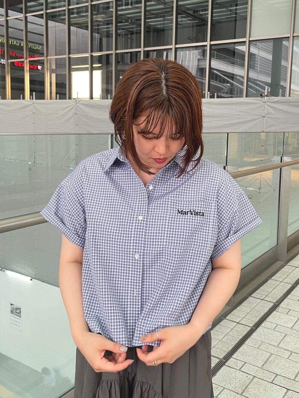 ブラック系のシャツ/ブラウス、グレー系のスカート、シルバー系のサンダルを着用したレディースの夏コーディネートの7枚目の写真