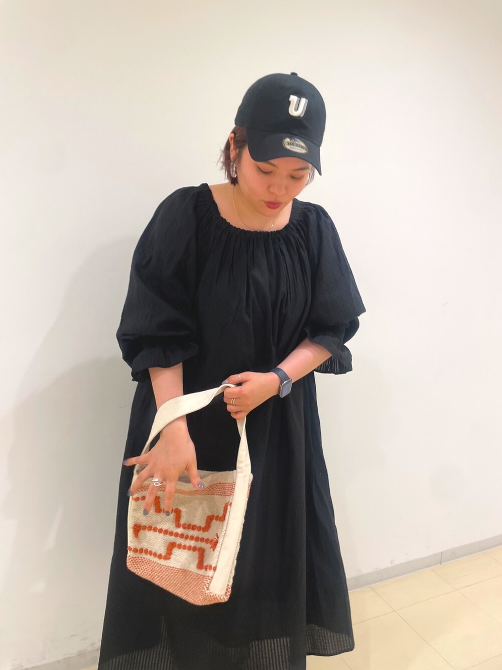 ブラック系のワンピース、ブラック系のキャップを着用したレディースの冬コーディネートの4枚目の写真