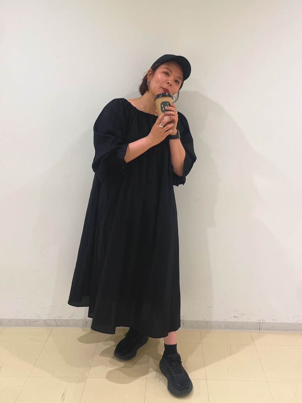 ブラック系のワンピース、ブラック系のキャップを着用したレディースの冬コーディネートの2枚目の写真