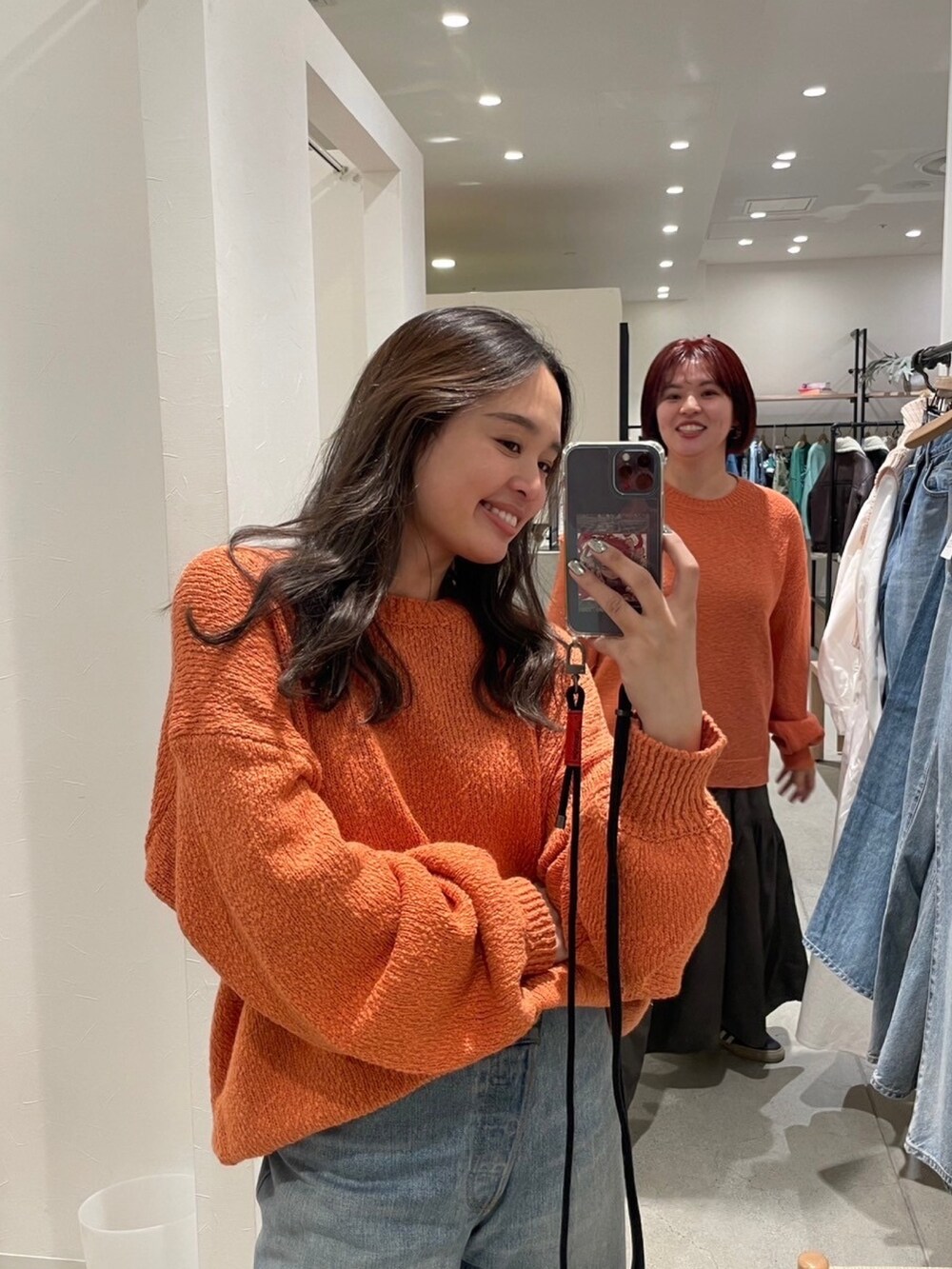 オレンジ系のニット/セーター、ホワイト系のその他パンツ、ゴールド系のパンプスを着用したレディースの冬コーディネートの8枚目の写真