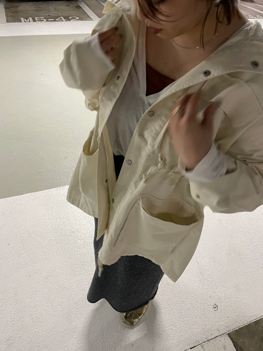 ホワイト系のブルゾン、グレー系のスカート、ホワイト系のTシャツ/カットソーを着用したレディースの冬コーディネートの7枚目の写真