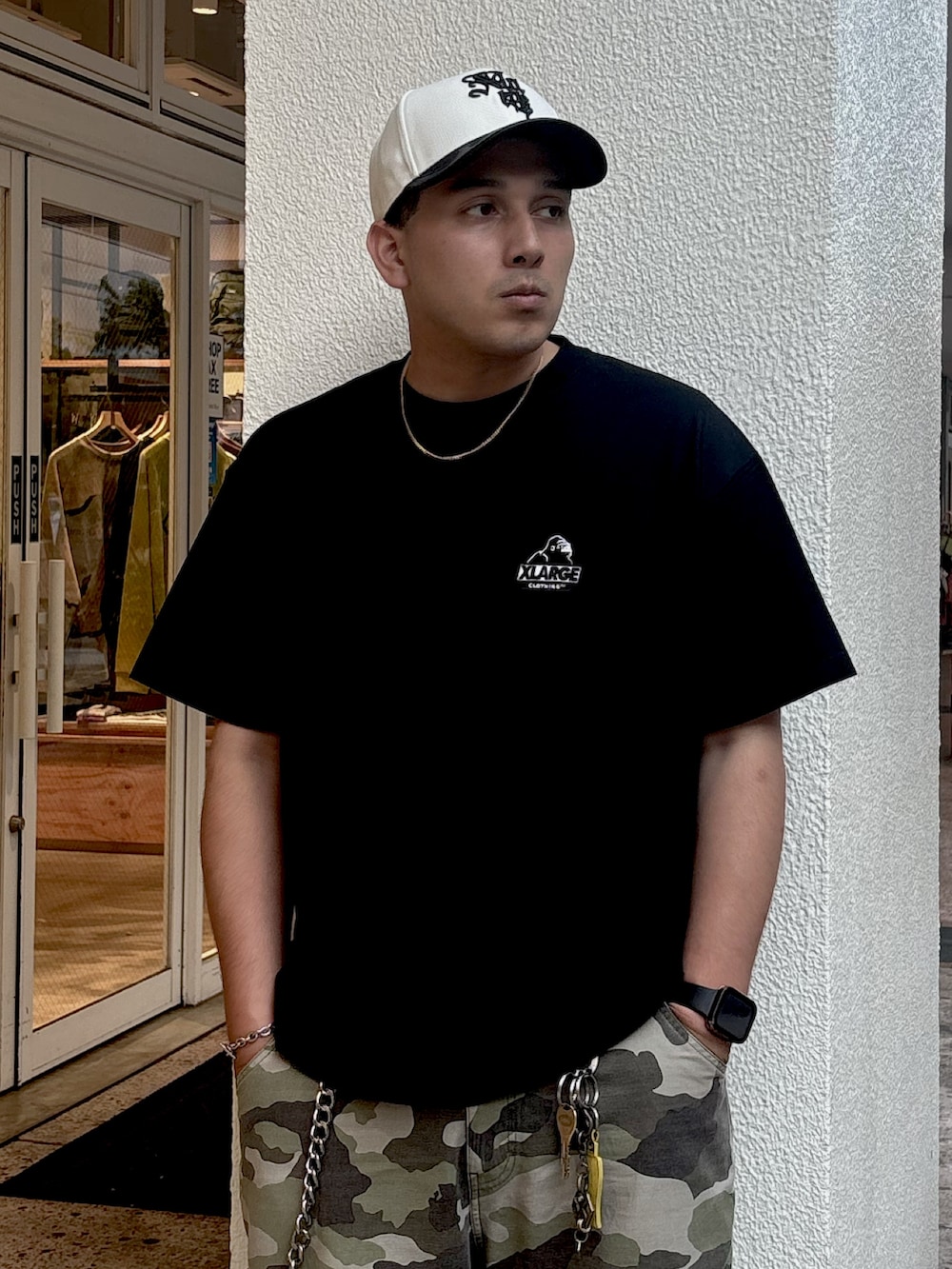 ブラック系のTシャツ/カットソー、その他のカーゴパンツ、ホワイト系のキャップを着用したメンズの夏コーディネートの2枚目の写真