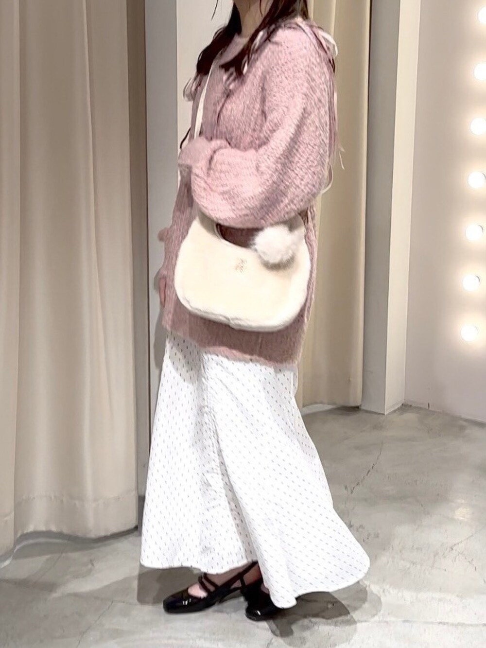 ピンク系のニット/セーター、ホワイト系のハンドバッグ、ホワイト系のスカートを着用したレディースの冬コーディネートの8枚目の写真