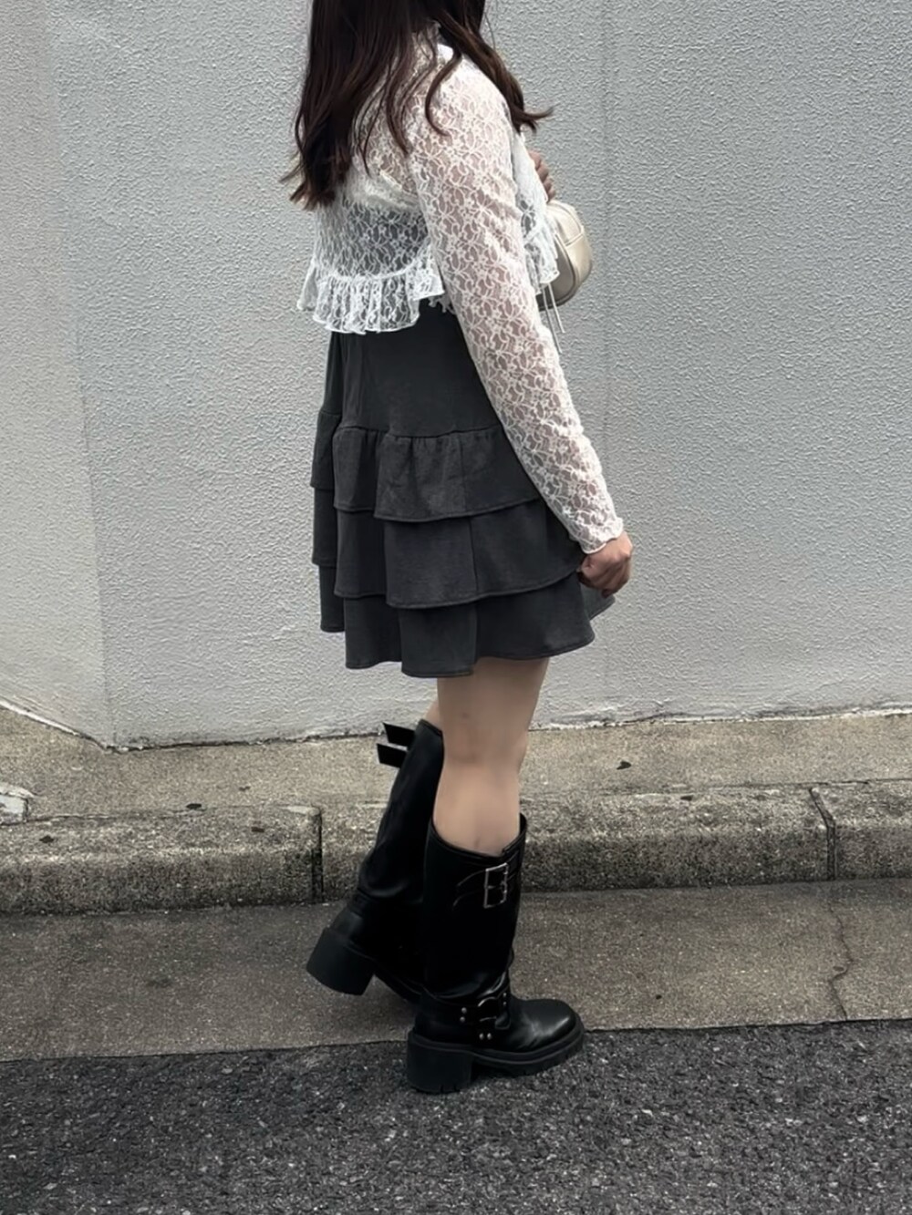 グレー系のワンピース、ホワイト系のボストンバッグ、ブラック系のブーツを着用したレディースの秋コーディネートの7枚目の写真