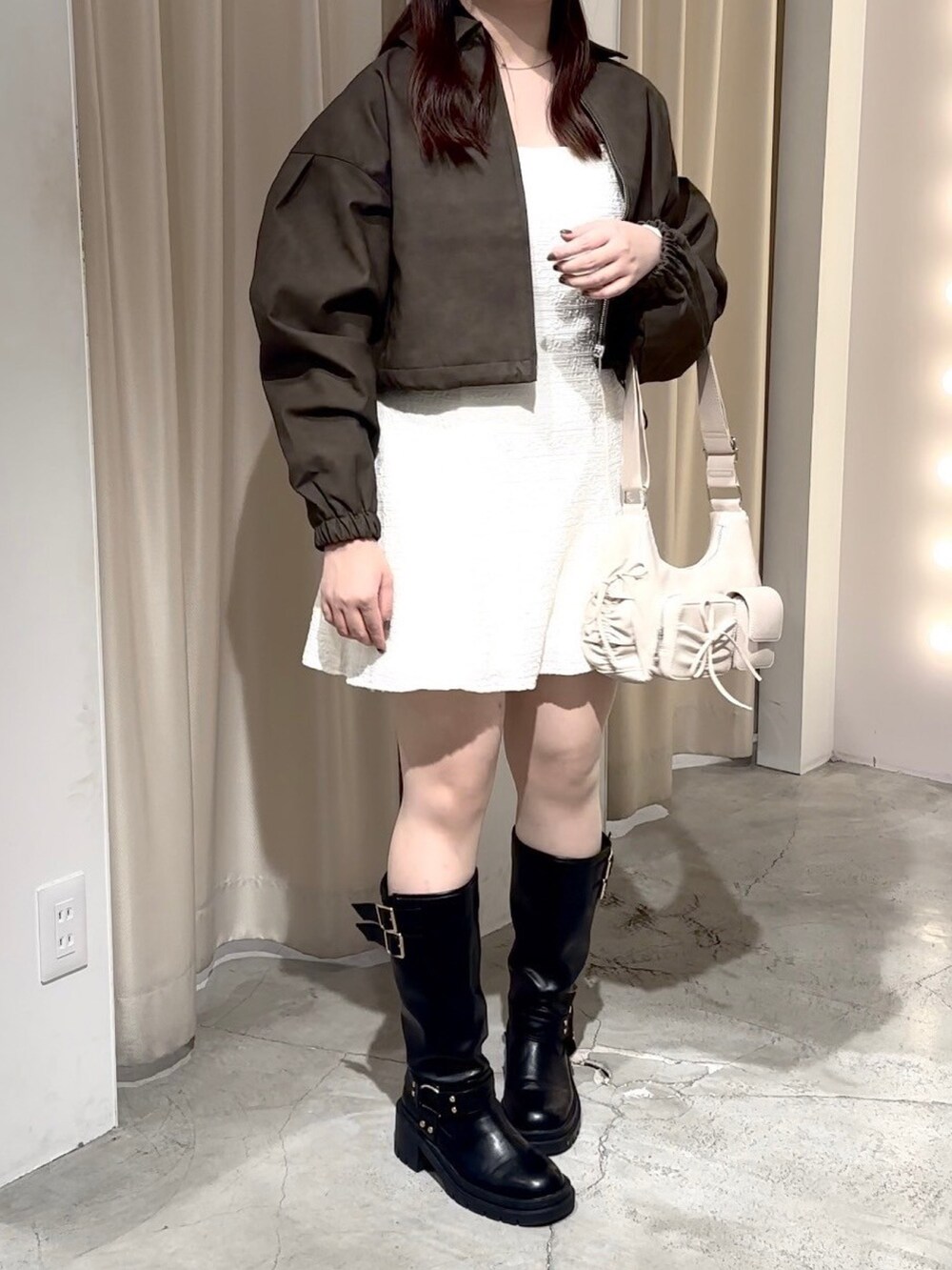 ベージュ系のワンピース、ホワイト系のショルダーバッグ、ブラック系のブーツを着用したレディースの秋コーディネートの5枚目の写真