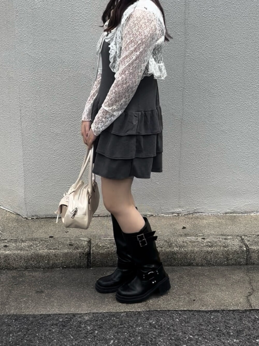 グレー系のワンピース、ホワイト系のボストンバッグ、ブラック系のブーツを着用したレディースの秋コーディネートの4枚目の写真