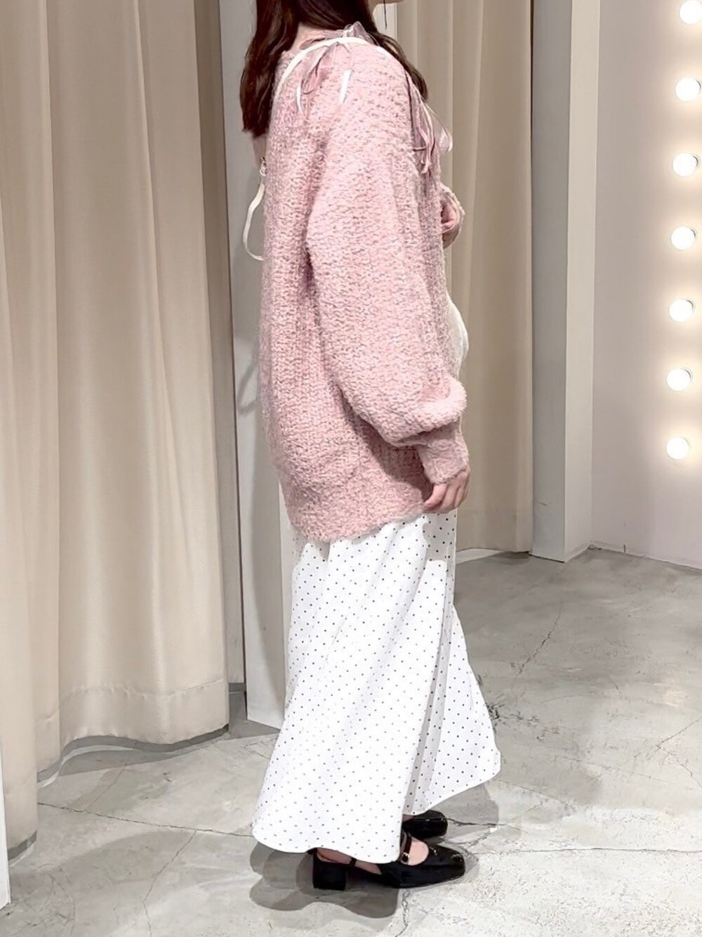 ピンク系のニット/セーター、ホワイト系のハンドバッグ、ホワイト系のスカートを着用したレディースの冬コーディネートの3枚目の写真