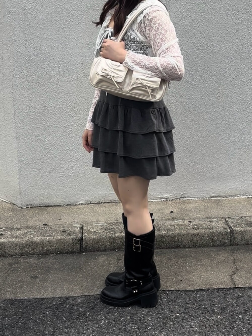 グレー系のワンピース、ホワイト系のボストンバッグ、ブラック系のブーツを着用したレディースの秋コーディネートの9枚目の写真