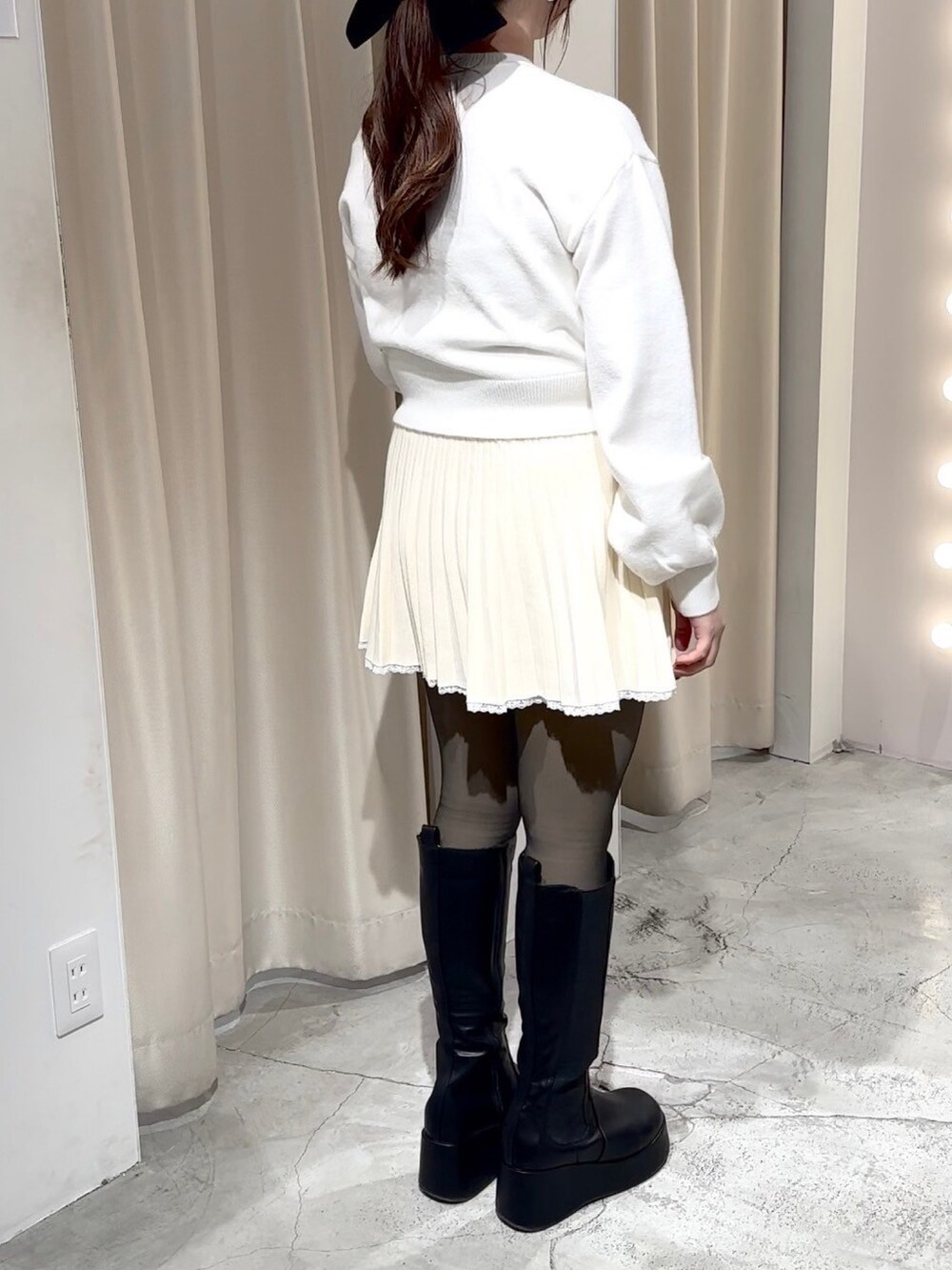 ホワイト系のニット/セーター、ホワイト系のワンピース、ホワイト系のハンドバッグを着用したレディースの冬コーディネートの5枚目の写真