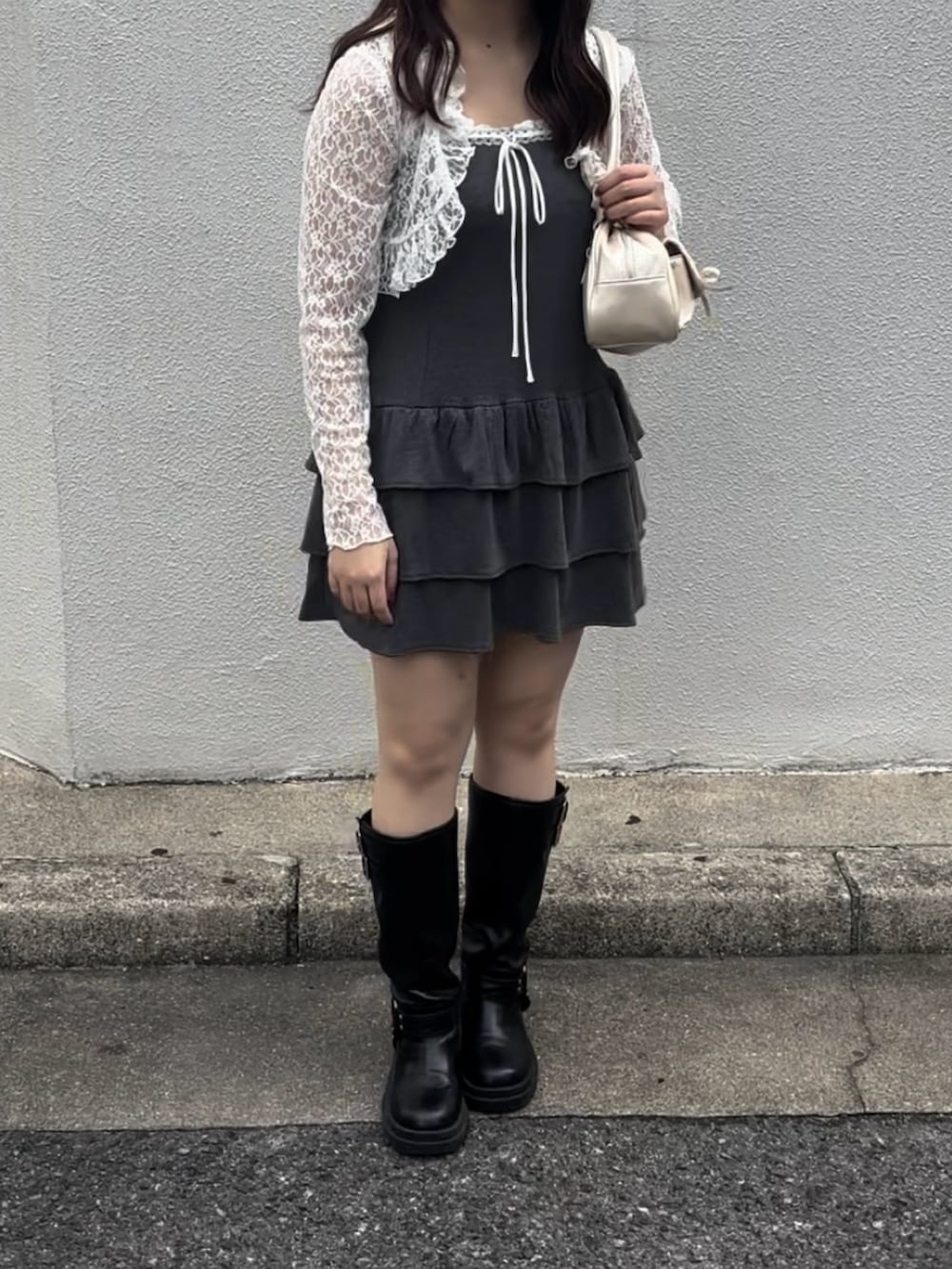 グレー系のワンピース、ホワイト系のボストンバッグ、ブラック系のブーツを着用したレディースの秋コーディネートの6枚目の写真