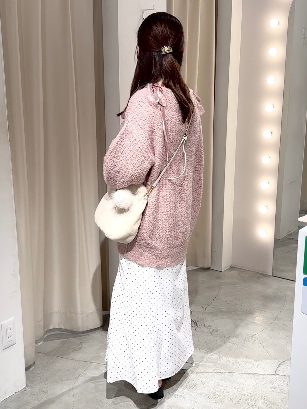 ピンク系のニット/セーター、ホワイト系のハンドバッグ、ホワイト系のスカートを着用したレディースの冬コーディネートの6枚目の写真