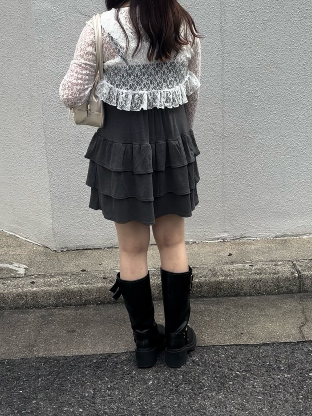 グレー系のワンピース、ホワイト系のボストンバッグ、ブラック系のブーツを着用したレディースの秋コーディネートの8枚目の写真