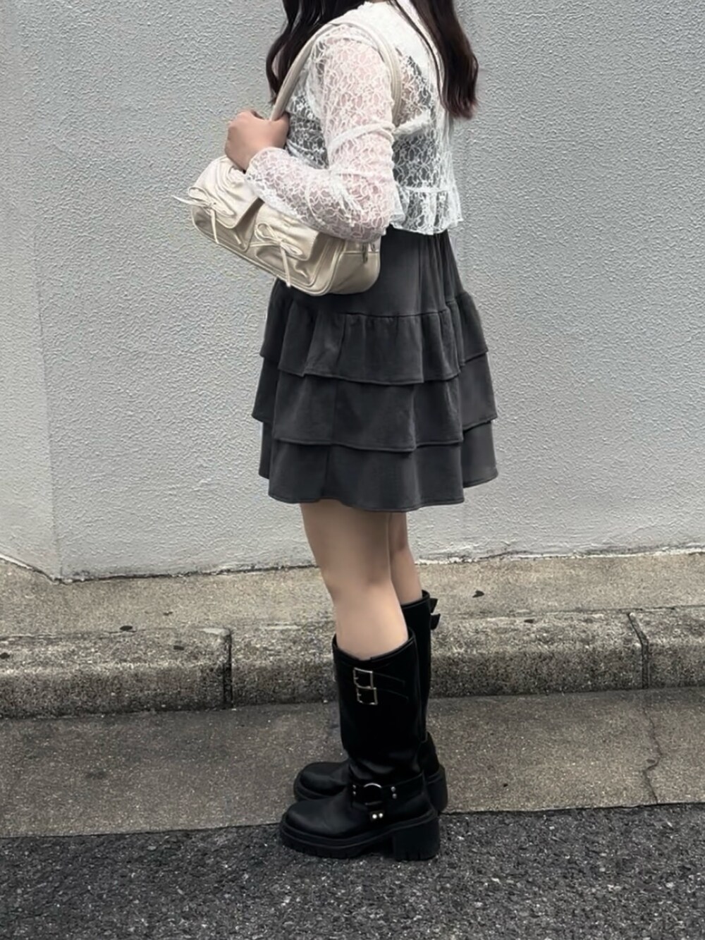 グレー系のワンピース、ホワイト系のボストンバッグ、ブラック系のブーツを着用したレディースの秋コーディネートの5枚目の写真