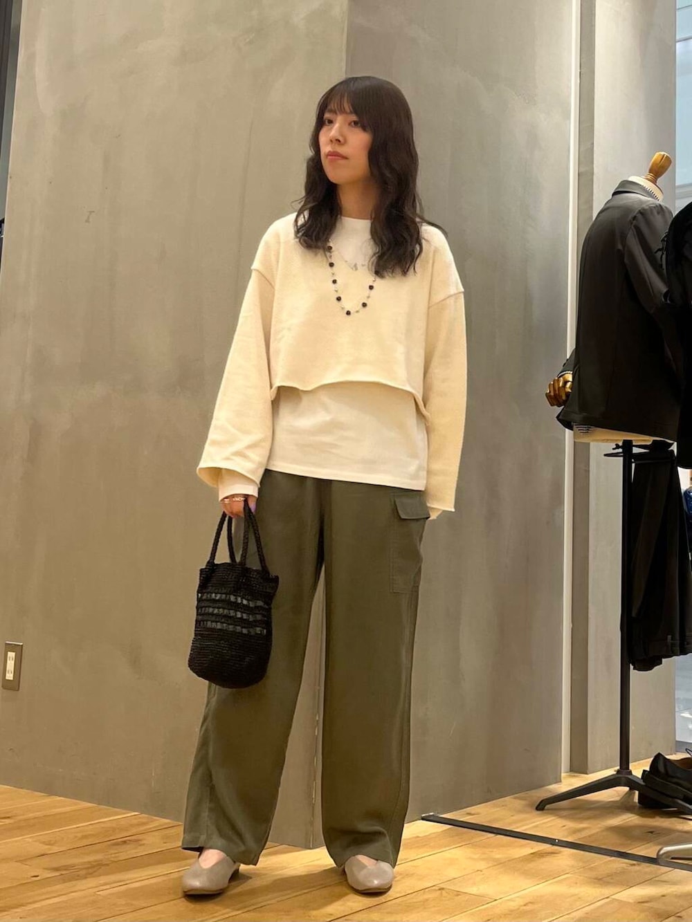 グレー系のパンプス、ホワイト系のTシャツ/カットソー、ブラック系のショルダーバッグを着用したレディースの冬コーディネートの2枚目の写真