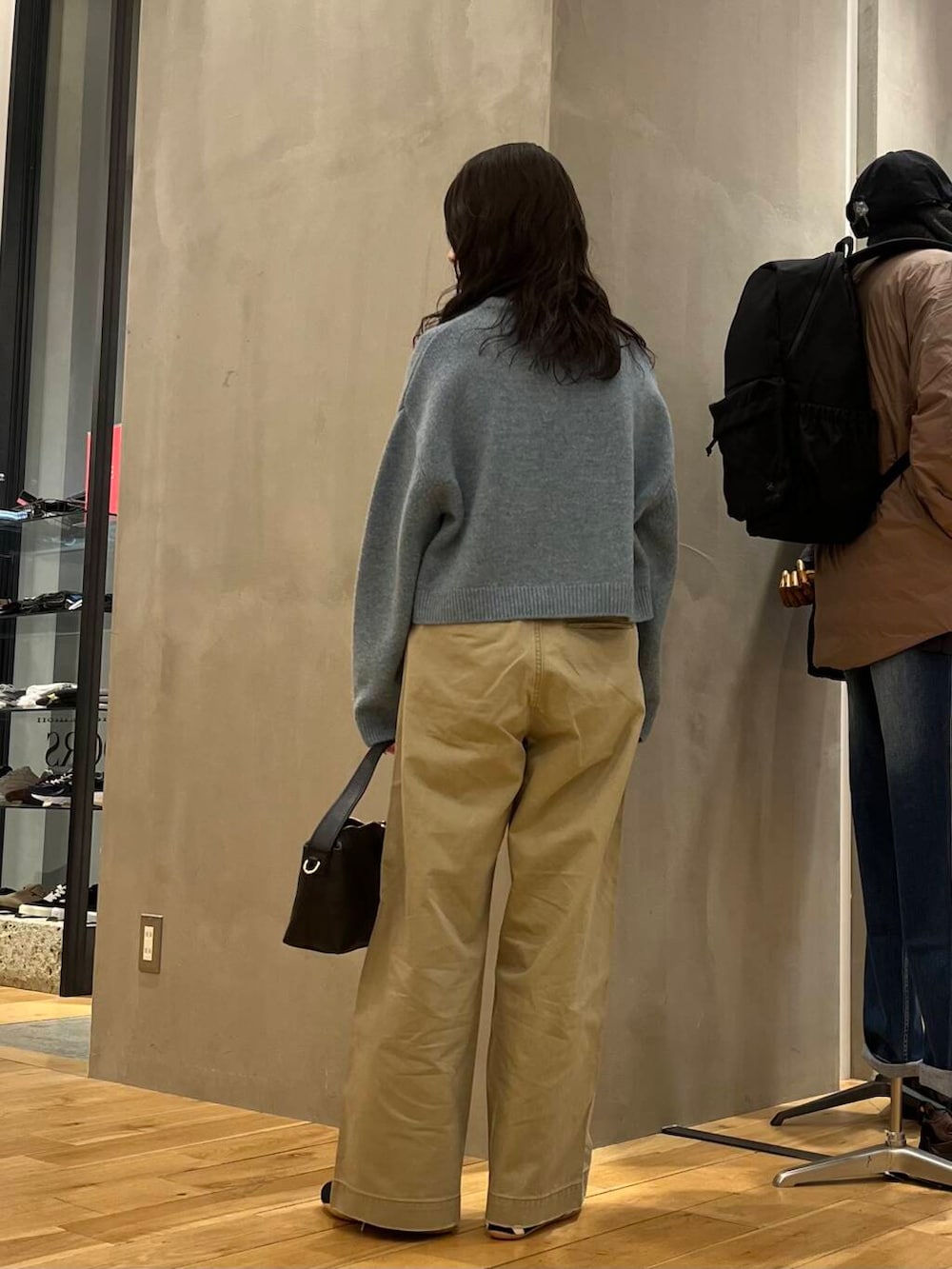 ブルー系のニット/セーター、ブラック系のショルダーバッグを着用したレディースの冬コーディネートの3枚目の写真