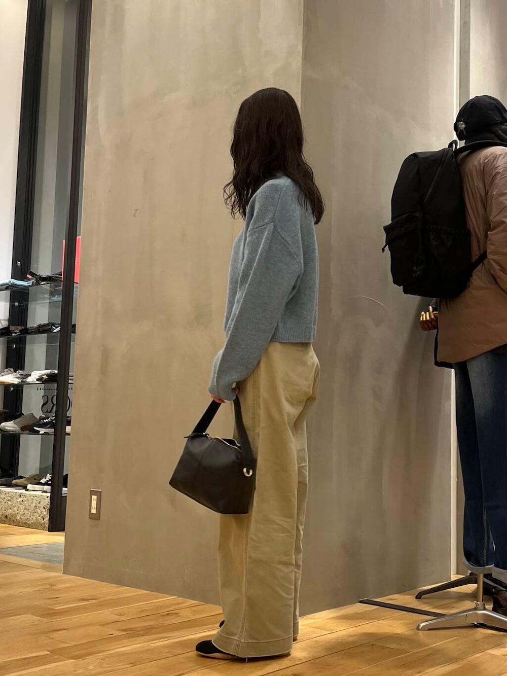 ブルー系のニット/セーター、ブラック系のショルダーバッグを着用したレディースの冬コーディネートの2枚目の写真