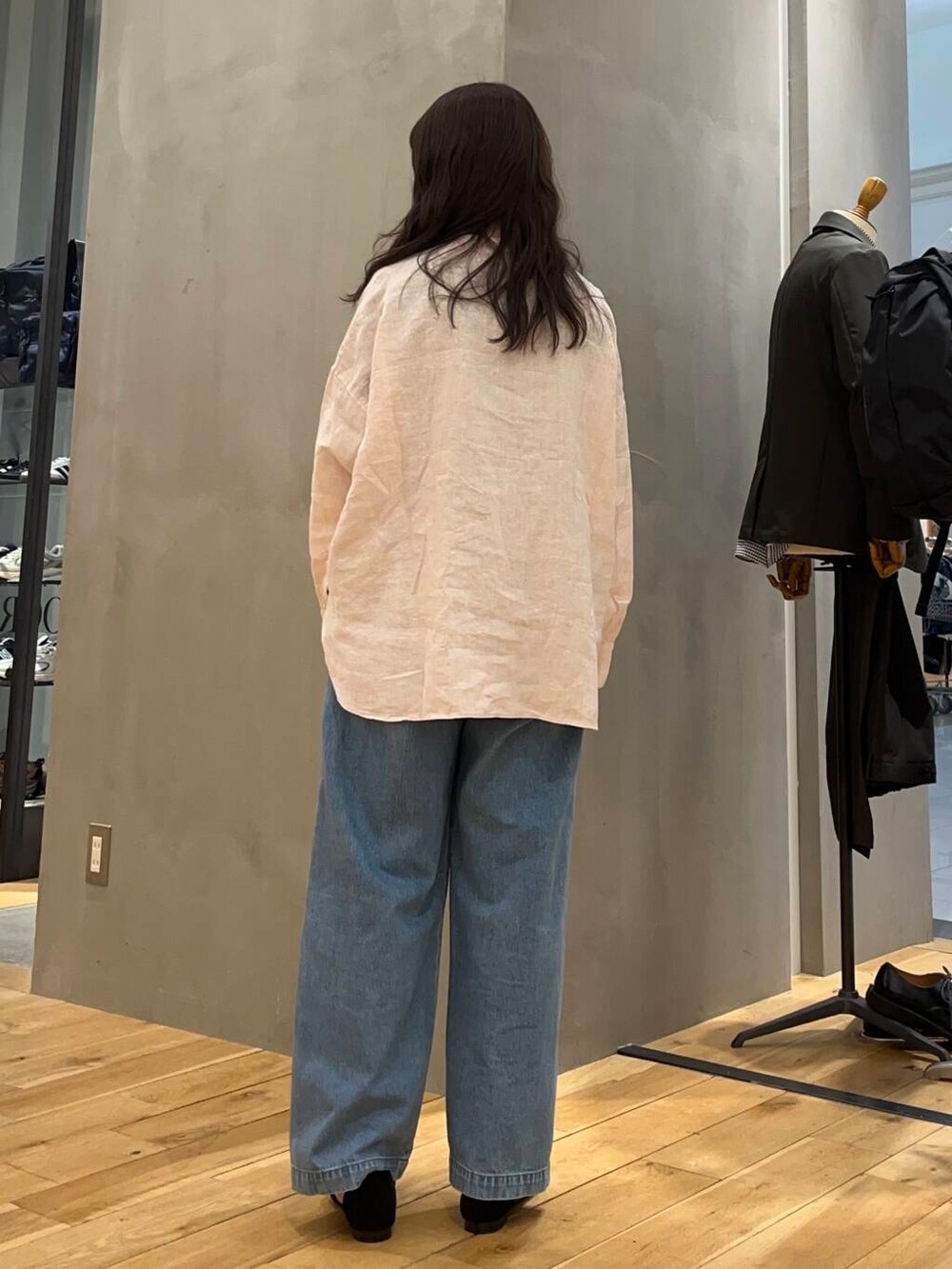 ブルー系のデニムパンツ、ブラック系のショルダーバッグ、ピンク系のシャツ/ブラウスを着用したレディースの春コーディネートの3枚目の写真