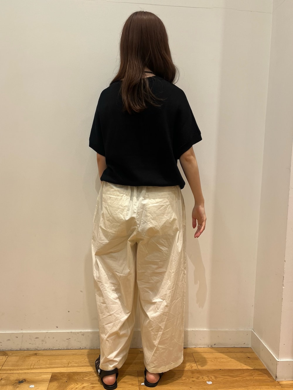 ブラック系のニット/セーター、ホワイト系のその他パンツを着用したレディースの夏コーディネートの3枚目の写真